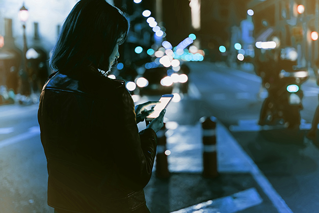 Woman using her phone at night.