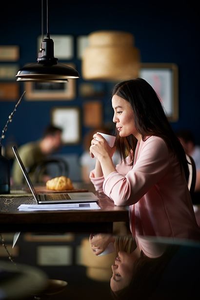 Young asian woman in coffee shop having a coffee.